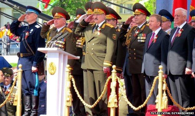 Ihar Shunievich salutes alongside other officials at the parade in Minsk