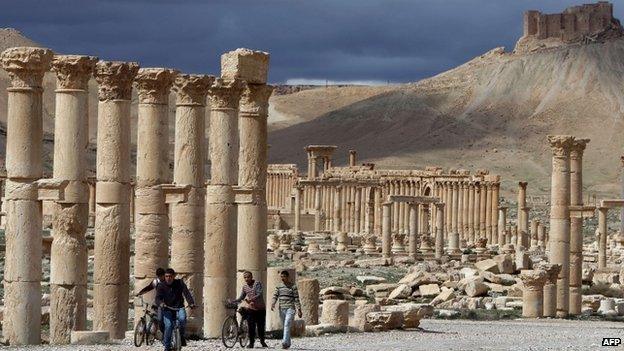 March 14, 2014 shows Syrian citizens riding their bicycles the ancient oasis city of Palmyra, 215 kilometres northeast of Damascus, on 14 March 2014