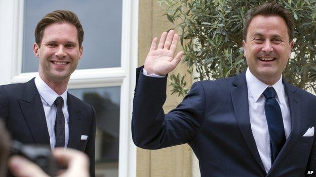 Luxembourg's Prime Minister Xavier Bettel, right, waves as he walks with his partner Gauthier Destenay as they arrive at the town hall for their marriage in Luxembourg, on Friday, 15 May 2015