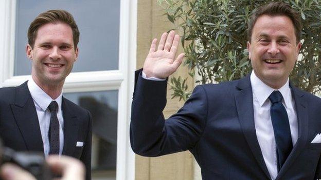 Luxembourg's Prime Minister Xavier Bettel, right, waves as he walks with his partner Gauthier Destenay as they arrive at the town hall for their marriage in Luxembourg, on Friday, 15 May 2015