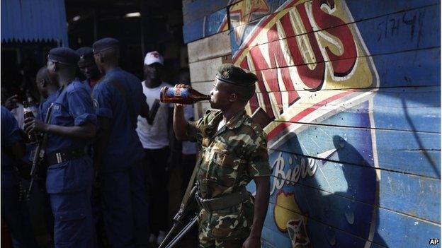 A soldier drinks beer with police officers in Bujumbura, 15 May 2015