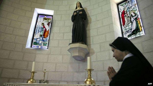 A sister prays in front of relics of Marie Alphonsine Ghattas at the Mamilla monastery in Jerusalem on May 12, 2015, a few days ahead of the canonisation of the Palestinian nun in Rome