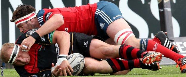 Munster's Billy Holland wrestles Dragons' Brok Harris to the ground in their Pro12 tie in Cork