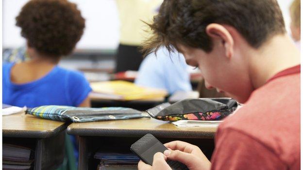 boy on mobile phone in the classroom