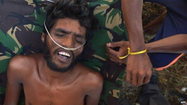 Indonesian medical team members tend to an unconscious Bangladeshi migrant