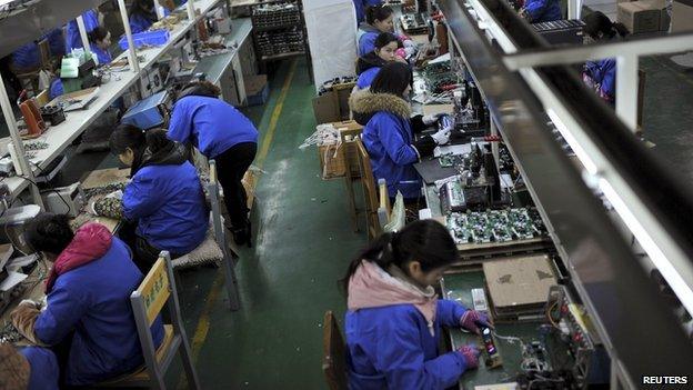 Employees assembling electronic components along a production line at a factory in Hefei, China