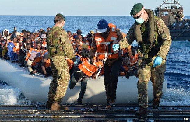 Royal Marines help migrants disembark on HMS Bulwark (13 May)