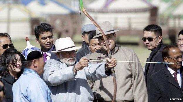 India"s Prime Minister Narendra Modi (C) draws a bow next to his Mongolian counterpart Chimed Saikhanbileg (4th R) as they attend a Naadam festival celebration on the outskirts of Ulan Bator, Mongolia, May 17, 2015