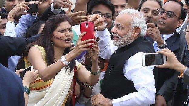 Indian Prime Minister Narendra Modi, front right, takes picture with an unidentified Indian woman upon his arrival at Seoul military airport in Seongnam, South Korea, Monday, May 18, 2015.