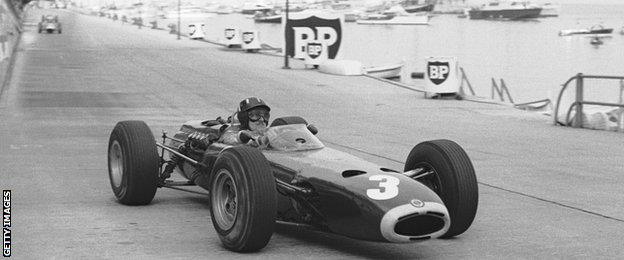 Graham Hill drives his BRM F1 car along the harbour straight at Monaco