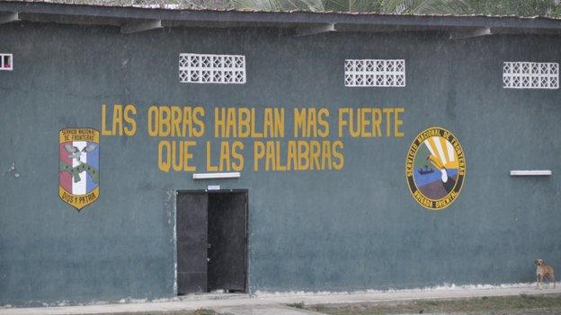 Mural reading "Deeds speak stronger than words" on the wall of a police training base in Darien