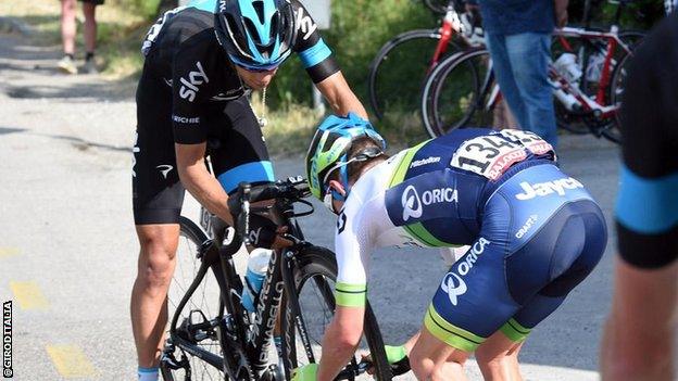 Simon Clarke fits a wheel to Richie Porte's bike