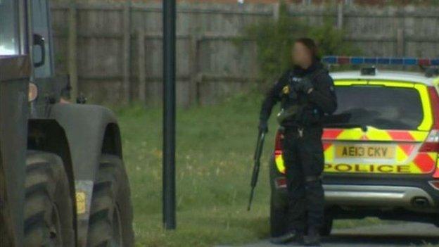 Police marksman near tractor
