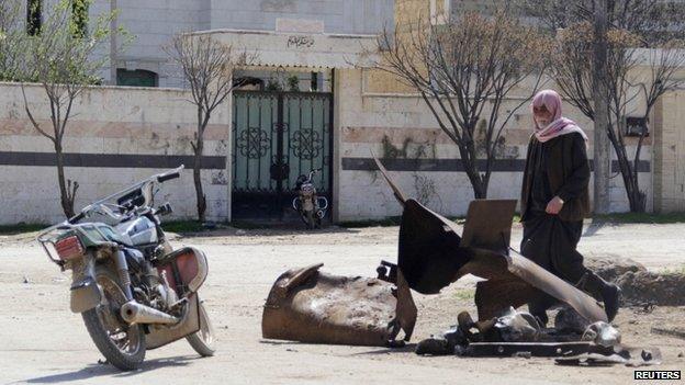 A man inspects a site targeted by what activists said was a poison gas attack in the village of Sarmin in Idlib province