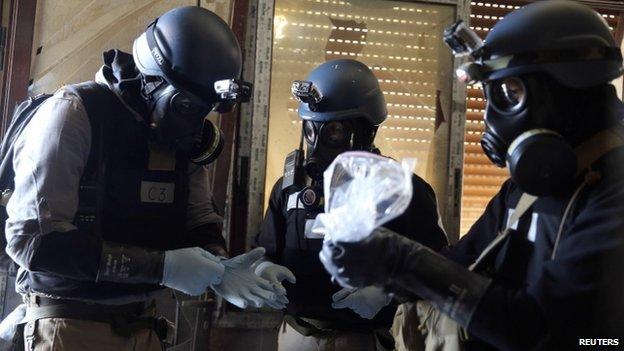 UN chemical weapons inspectors holding a plastic bag of samples in Damascus in August 2013