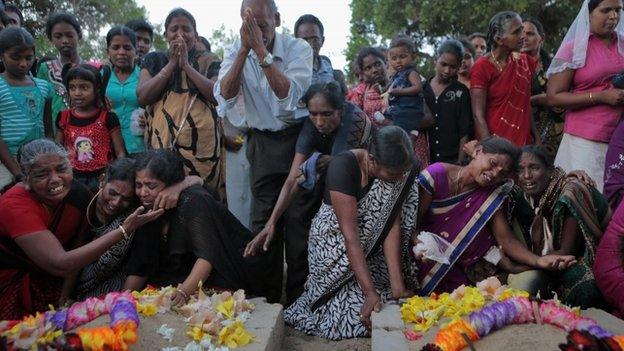 Sri Lankan ethnic Tamil women cry at the grave of their relatives who died in a fierce fighting between the army and Tamil Tiger rebels in Mullivaikkal, about 335 kilometers (208 miles) northeast of Sri Lanka, Monday, May 18, 2015.