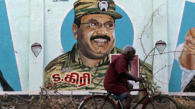 An Indian elderly man ride his bicycle near a mural of Sri Lanka"s Liberation Tigers of Tamil Eelam (LTTE) leader Velupillai Prabhakaran on a wall in Chennai, India, Tuesday, May 19, 2015.