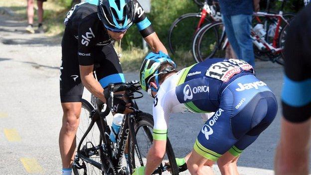 Simon Clarke fits a wheel to Richie Porte's bike