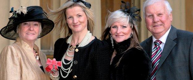 Maria Costello (2nd L) poses with her mother Eileen, father George and sister Tina after receiving her MBE