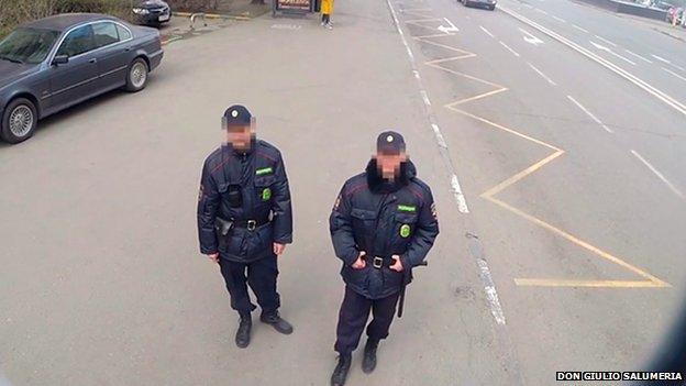 Russian police officers look at the billboard