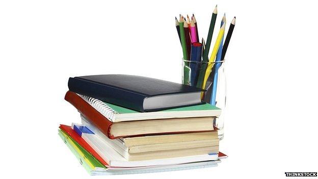 School books and pot of pens and pencils