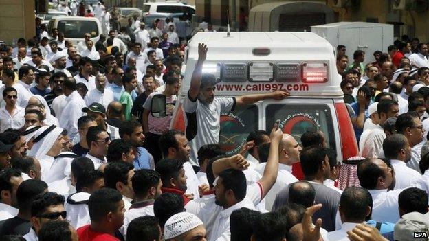 People gather around an ambulance following a suicide attack on the Shia Imam Ali mosque, in a village in Qatif, Saudi Arabia's Eastern Province, on Friday