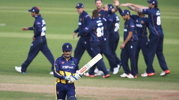 Essex celebrate in the background as Glamorgan's Jacques Rudolph walks back to the pavilion