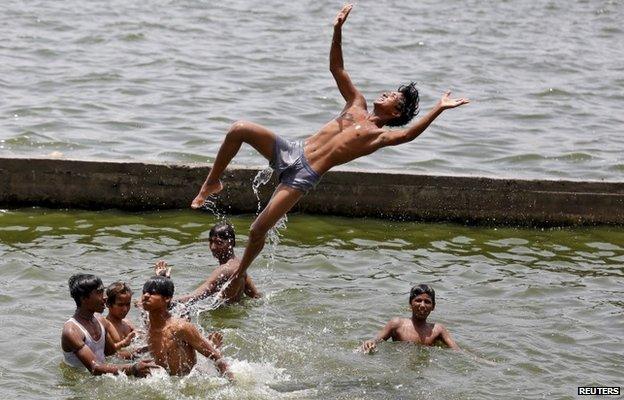 Boys cool off themselves in the waters of the river Sabarmati on a hot summer day in Ahmedabad, India, May 24, 2015.