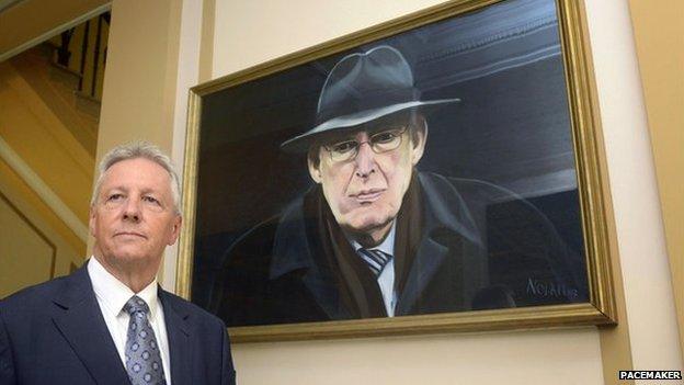 First Minister Peter Robinson standing beside a portrait of Ian Paisley which hangs at Stormont