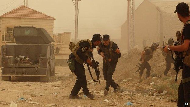 Iraqi security forces personnel take cover during fighting with Islamic State militants in Ramadi (14 May 2015)