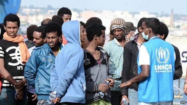 A UN refugee agency worker speaks to migrants disembarking in the port of Augusta (21 May 2015)