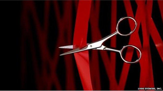 Scissors cutting red tape