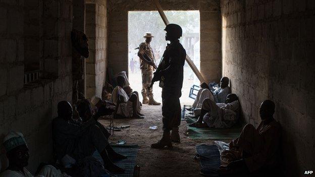 Nigerian soldier guarding civilians in Bama