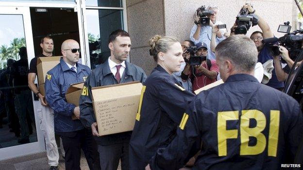 FBI investigators removing boxes from a building belonging to football authorities