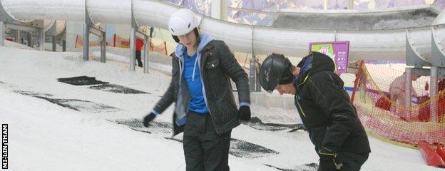 Ross and the instructor look down at their foot position in their skis