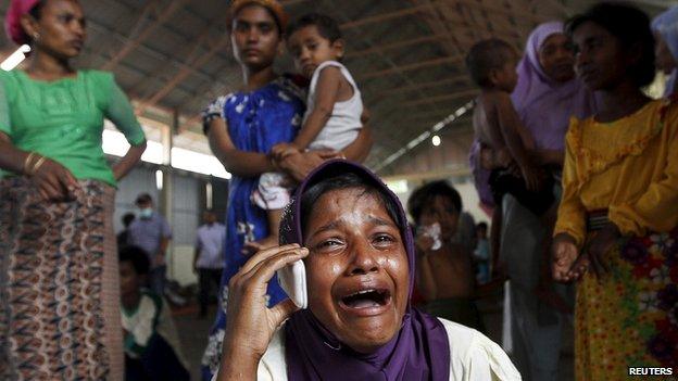 A Rohingya migrant who arrived in Indonesia by boat cries while speaking on a mobile phone with a relative in Malaysia