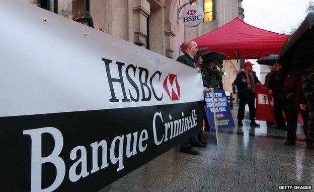 Members of the French Communist party, holding a banner reading 'HSBC, criminal bank' stage a protest outside the headquarters of HSBC on 26 February 2015 in Paris