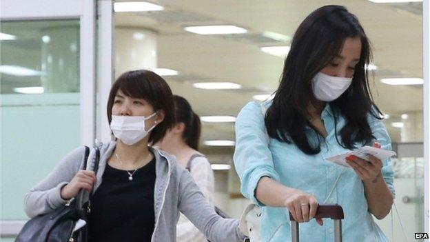 Two Japanese tourists wearing facial masks arrive at Gimpo airport, western Seoul, South Korea, 29 May 2015, as South Korea confirmed two additional cases of the Middle East Respiratory Syndrome (MERS), raising the number of patients diagnosed with the virus to nine.