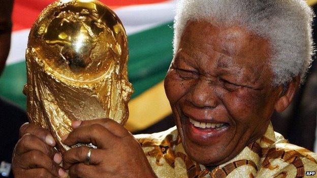 South African former President Nelson Mandela holds the World cup trophy in May 2004