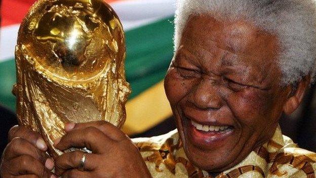 South African former President Nelson Mandela holds the World cup trophy in May 2004