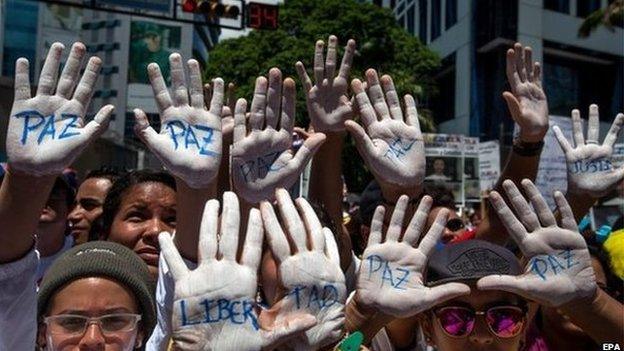 People show their hands painted in white and the word "Peace" during a demonstration against the Venezuelan government, in Caracas, Venezuela, 30 May 2015.