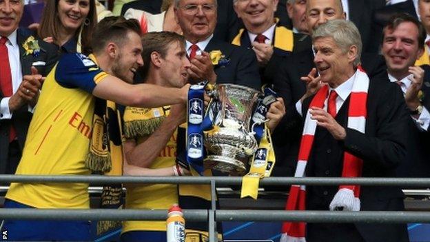 Aaron Ramsey (L) hands the FA Cup to Arsenal manager Arsene Wenger at Wembley