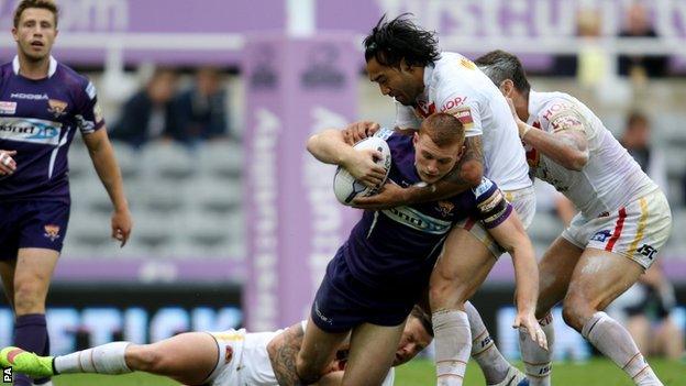 Giants back row forward Jack Hughes is held up by Catalan Dragons' Zeb Taia