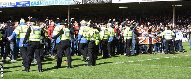 Police and stewards had to usher Motherwell fans off the pitch after the game