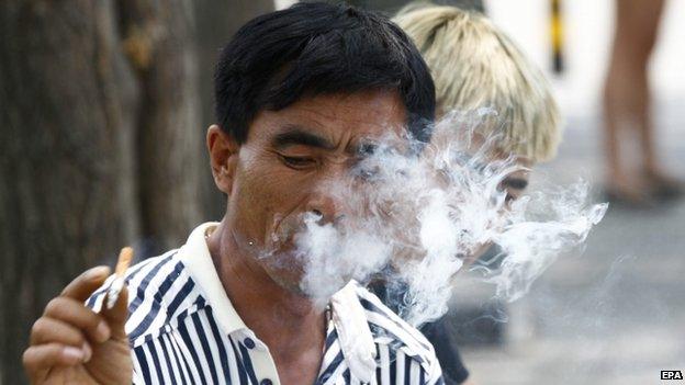 A Chinese man disposes his cigarette at a park area of the Bird"s Nest stadium, where a ceremony just concluded marking World No Tobacco Day in Beijing, China, 31 May 2015