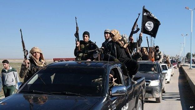 Islamic State militants pass by a convoy in Tel Abyad town, north-eastern Syria (04 May 2015)