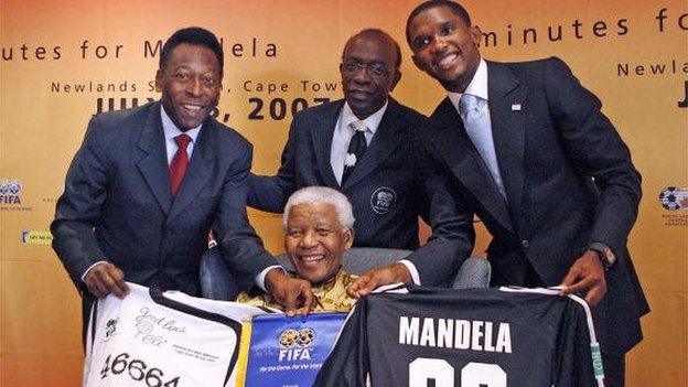 Former South African President, Nelson Mandela, is presented 17 July 2007 by (back, from L) Brazilian football legend, Pele, FIFA Vice President Jack Warner and Cameroon and Barcelona striker, Samuel Eto'o, the jersey, that will be used by the African and FIFA Invitation teams during the '90 Minutes for Mandela' match, to be played at Newlands Stadium in Cape Town on 18 July