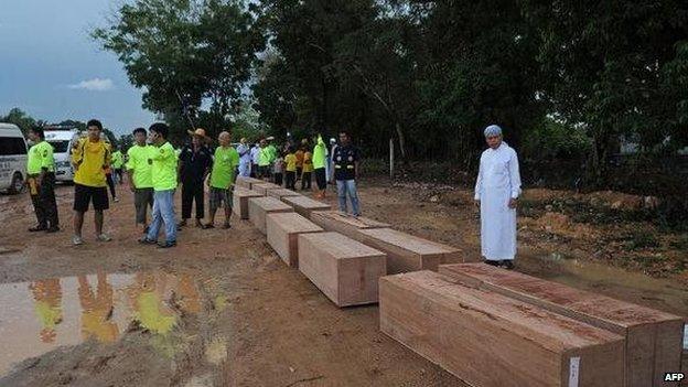 Thai rescue workers with coffins containing the remains of migrants exhumed from a jungle camp in the southern Songkhla province (03 May 2015)