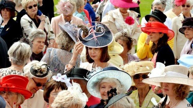 A woman keeps a firm grip on her hat in windy weather as the Duchess of Cornwall hosts a Garden Party in honour of the centenary of the Women's Institute, held at Buckingham Palace, London