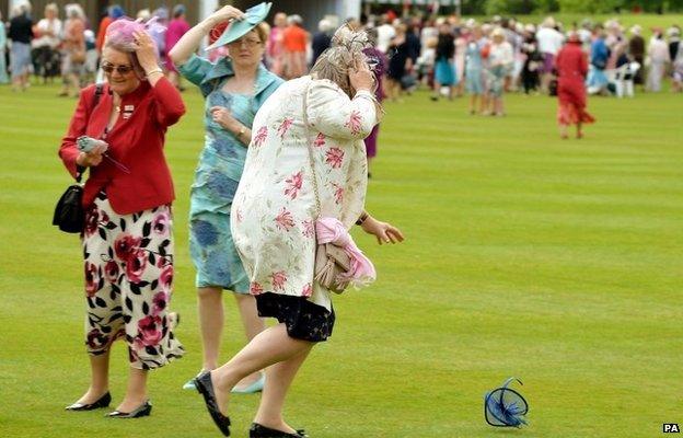 A woman chases a hat in the wind as the Duchess of Cornwall hosts a Garden Party in honour of the centenary of the Women's Institute, held at Buckingham Palace.